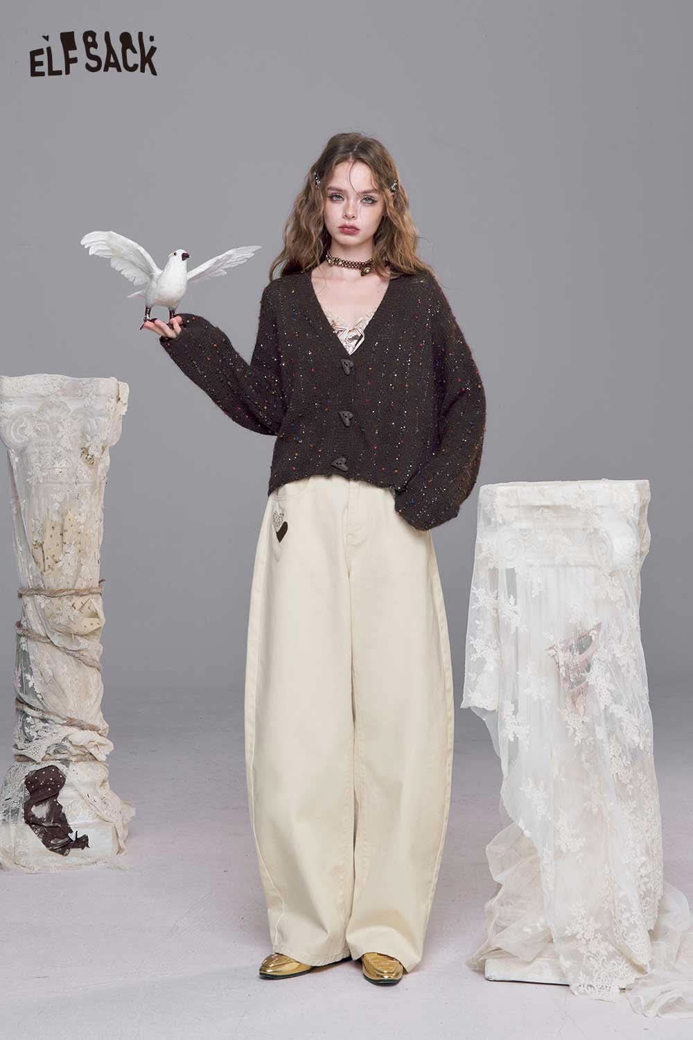 Stylish model wearing ELFSACK heart embroidery white wide leg jeans paired with a dark sweater