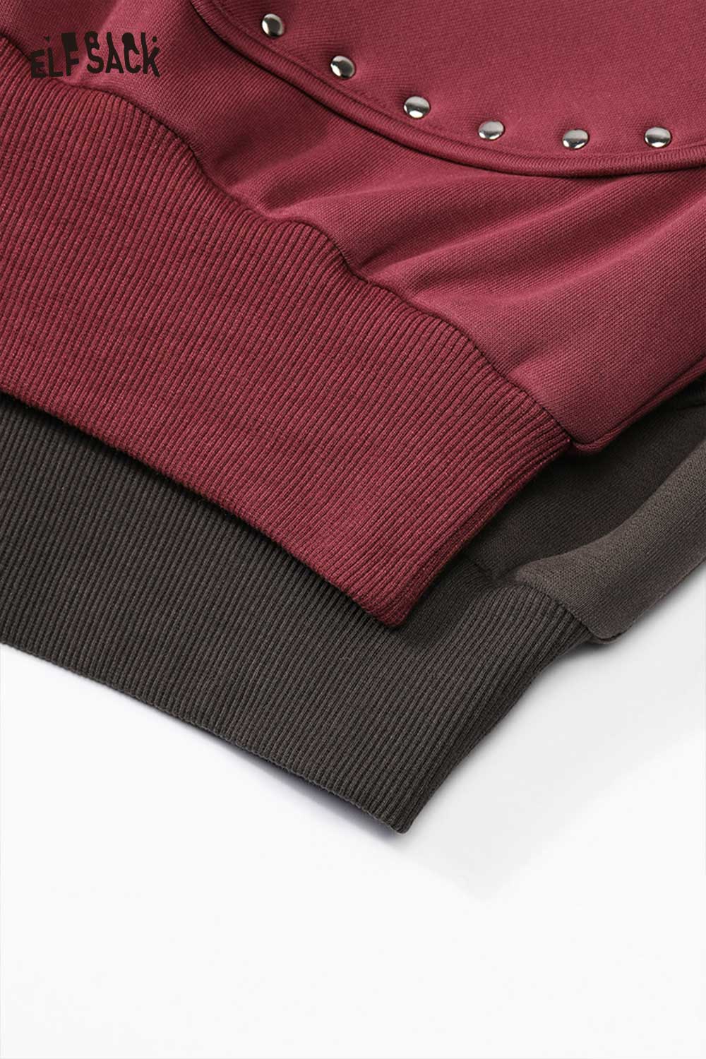 Close-up of ELFSACK heart patchwork hooded sweatshirt showing ribbed cuffs in burgundy and dark green