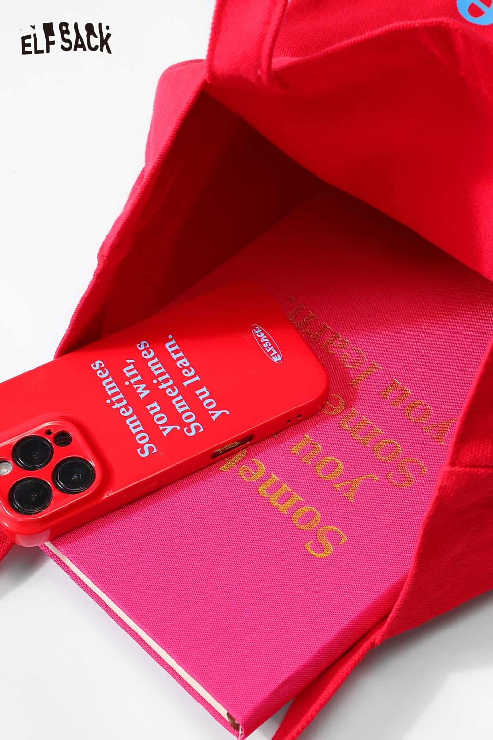 ELFSACK heavy duty canvas tote bag in red with interior pocket and phone beside a notebook