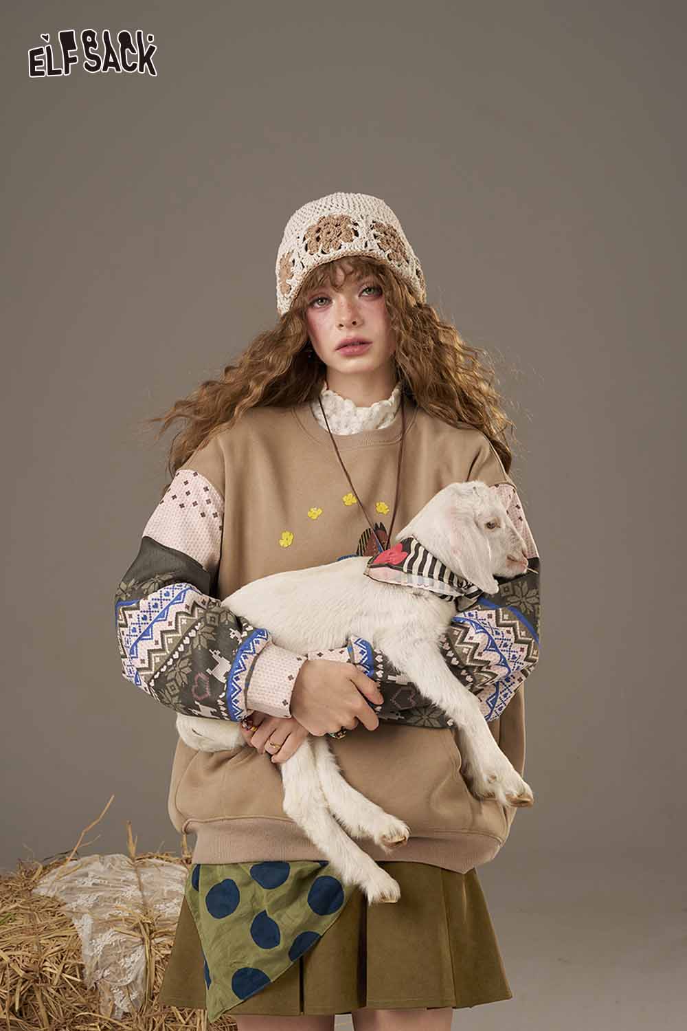ELFSACK high waist pleated skirt styled with a cozy sweater and holding a goat