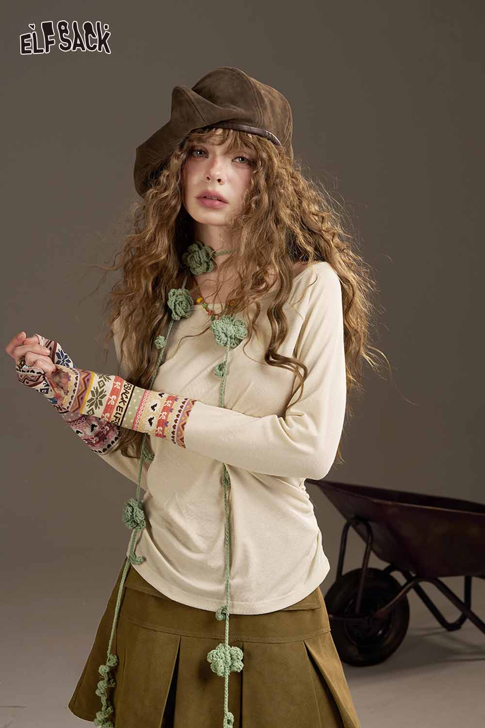 Model wearing an ELFSACK high waist pleated skirt paired with a casual top and stylish accessories