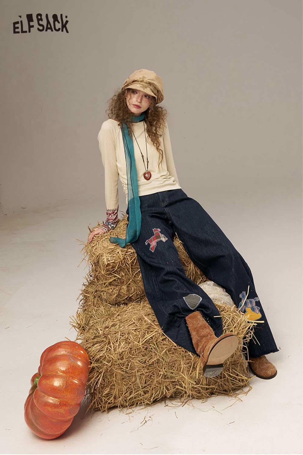 ELFSACK model wearing high waisted wide leg denim pants styled with a cozy sweater and hat