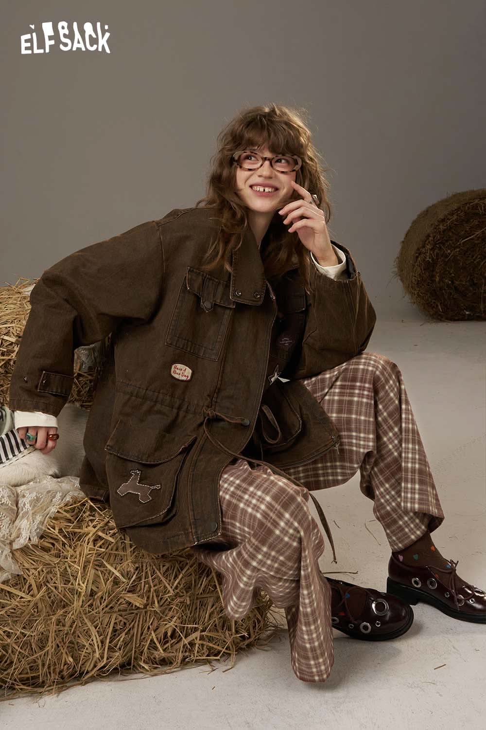 ELFSACK lace plaid straight leg pants displayed on a model sitting comfortably with a brown jacket