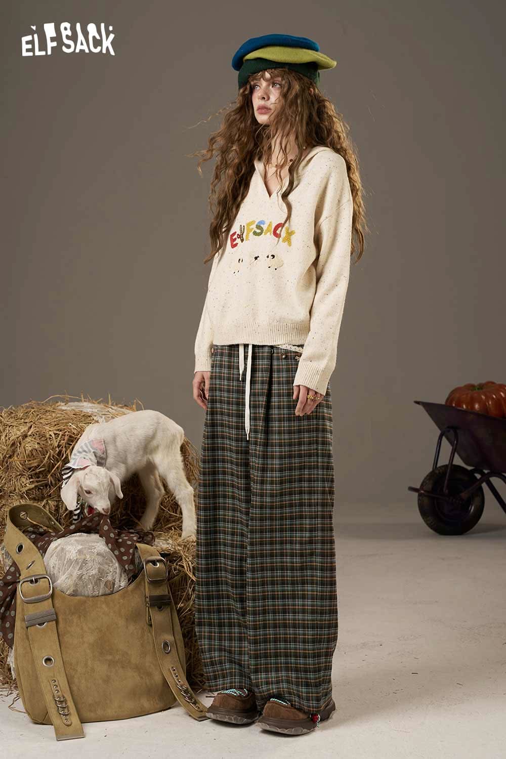 ELFSACK lace plaid straight leg pants styled with a cozy sweater and vibrant hat in a rustic setting