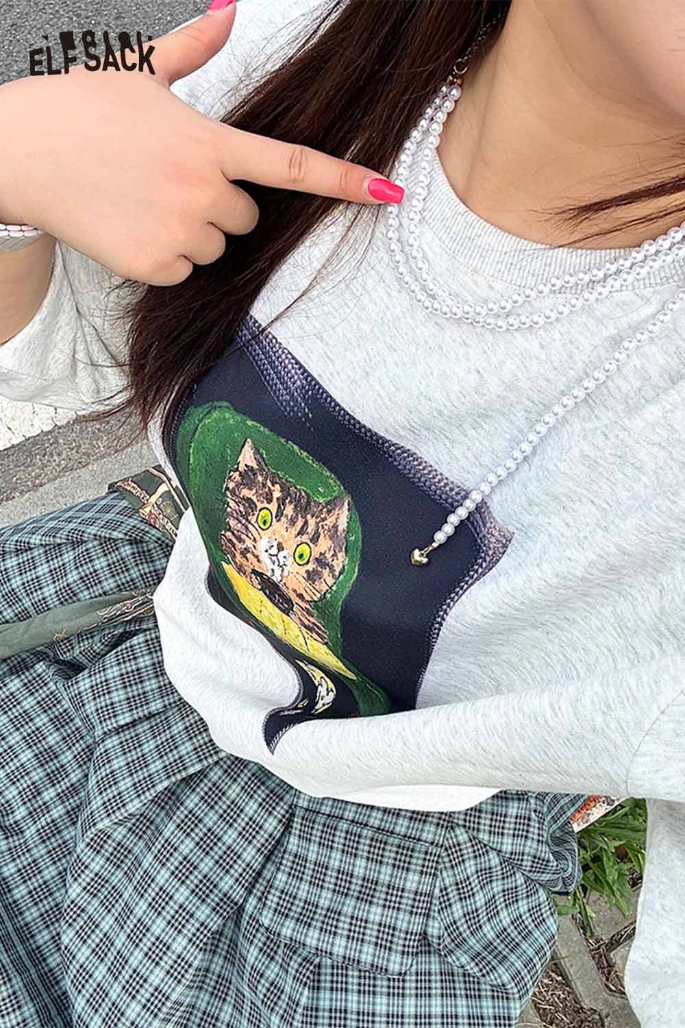 ELFSACK layered pearl choker necklace styled with graphic sweatshirt and plaid skirt