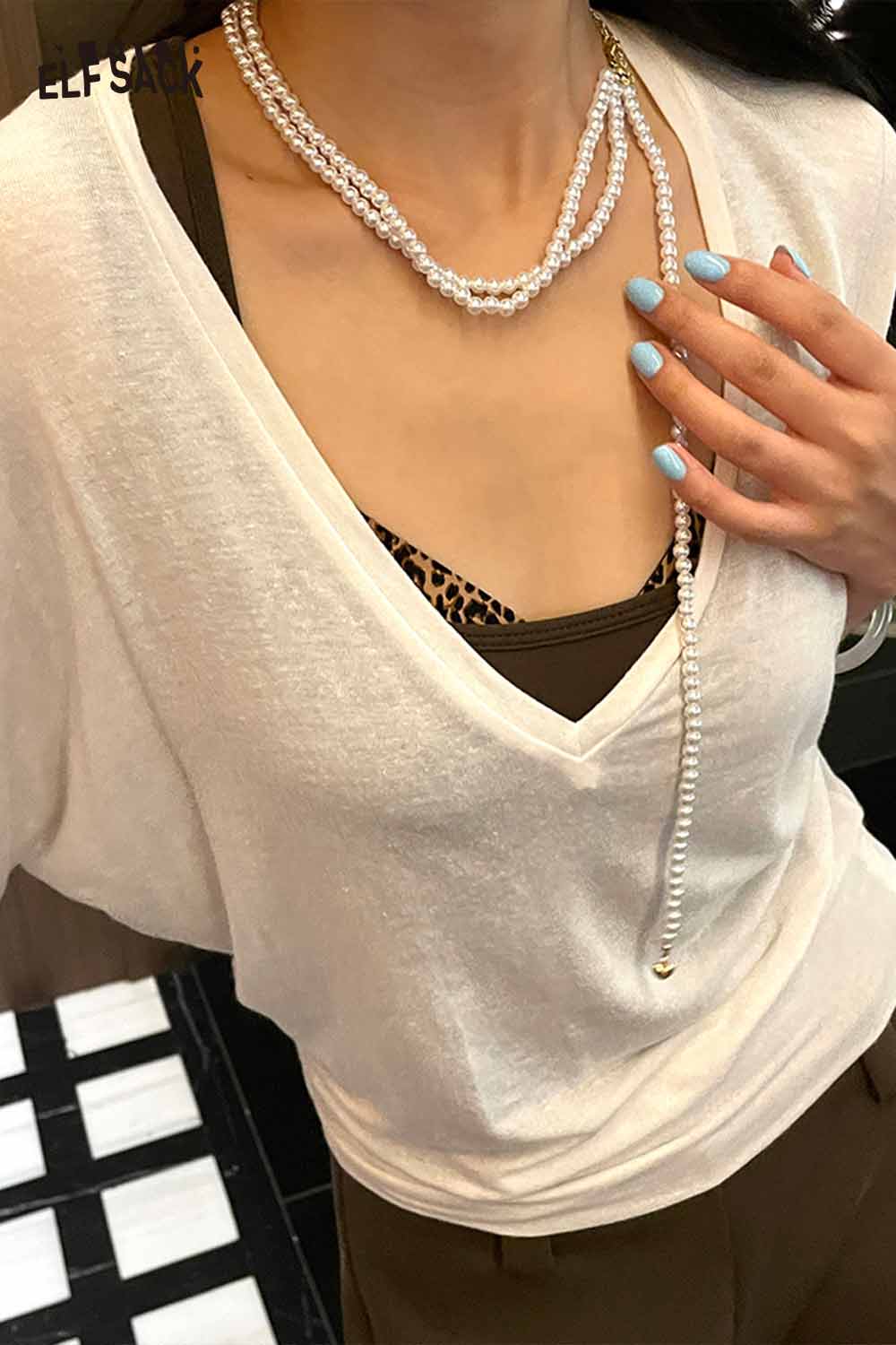 Layered pearl choker necklace styled with a casual V-neck top and brown accents