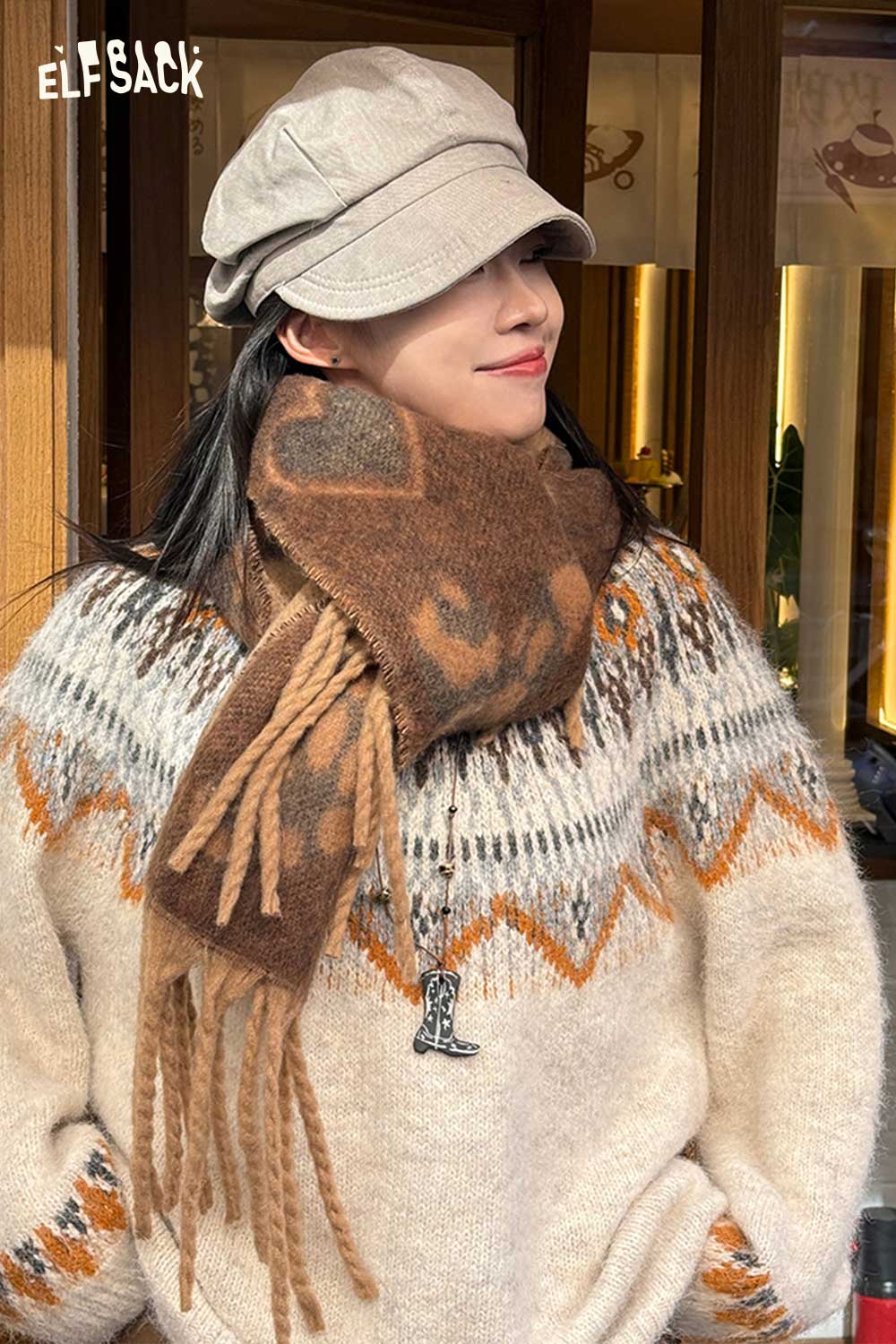ELFSACK leopard heart fringe scarf in warm tones, styled with a cozy sweater and hat