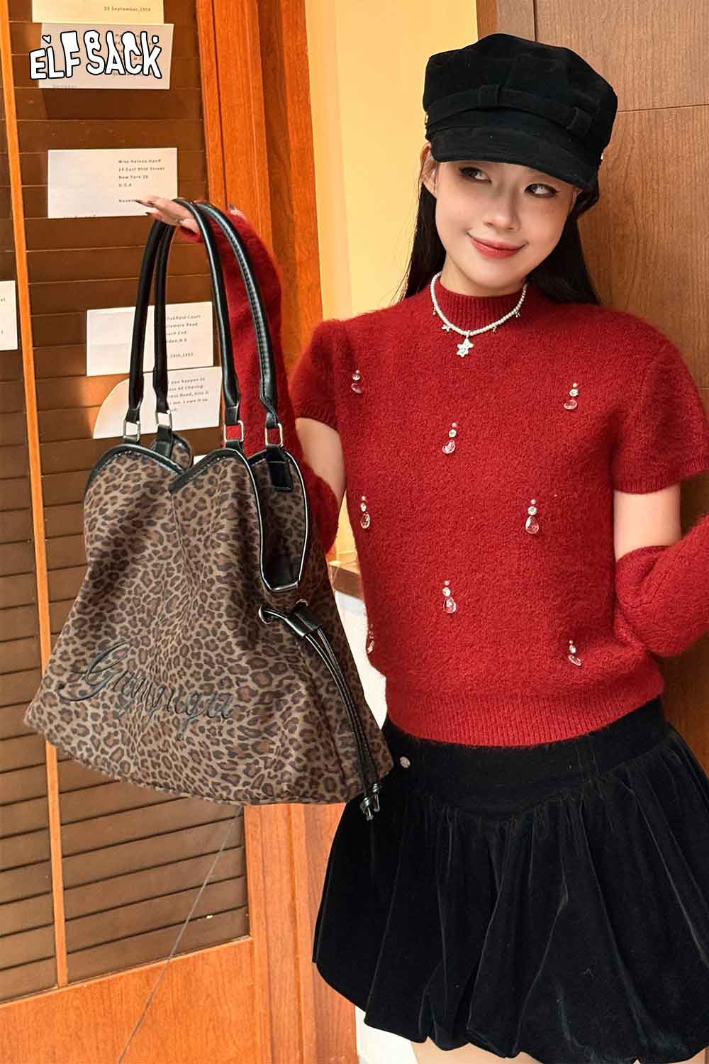 ELFSACK leopard print tote bag displayed by a model in a red sweater and black skirt