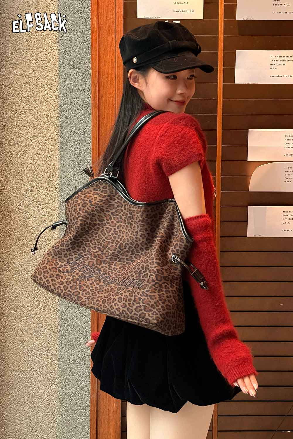 Stylish woman wearing a leopard print tote bag paired with a red sweater and black skirt