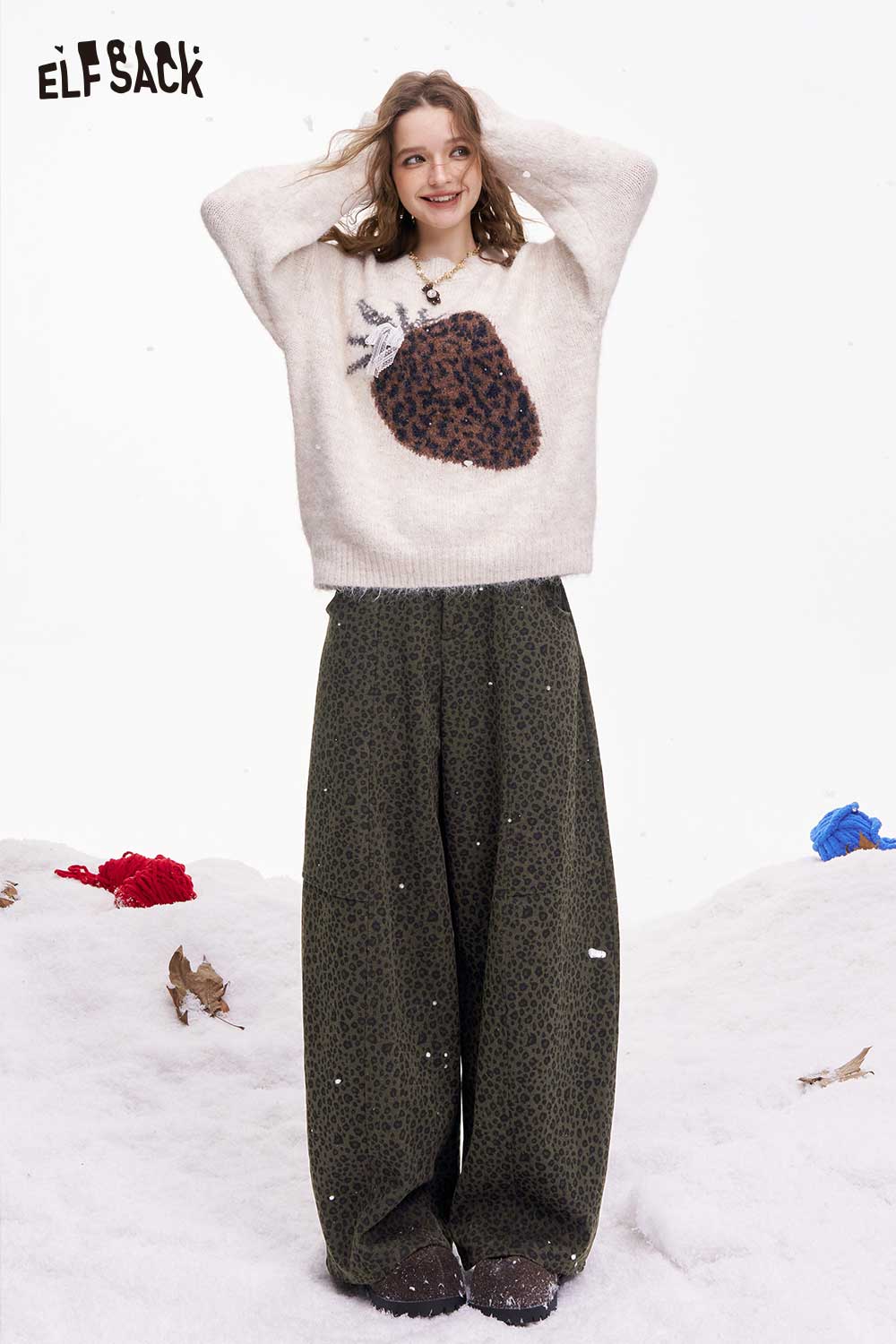ELFSACK leopard print wide leg pants styled with a cozy sweater in a snowy setting