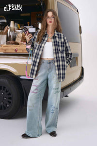 ELFSACK model wearing women's dark blue plaid graphic shirt over white crop top with wide leg embroidered jeans by van
