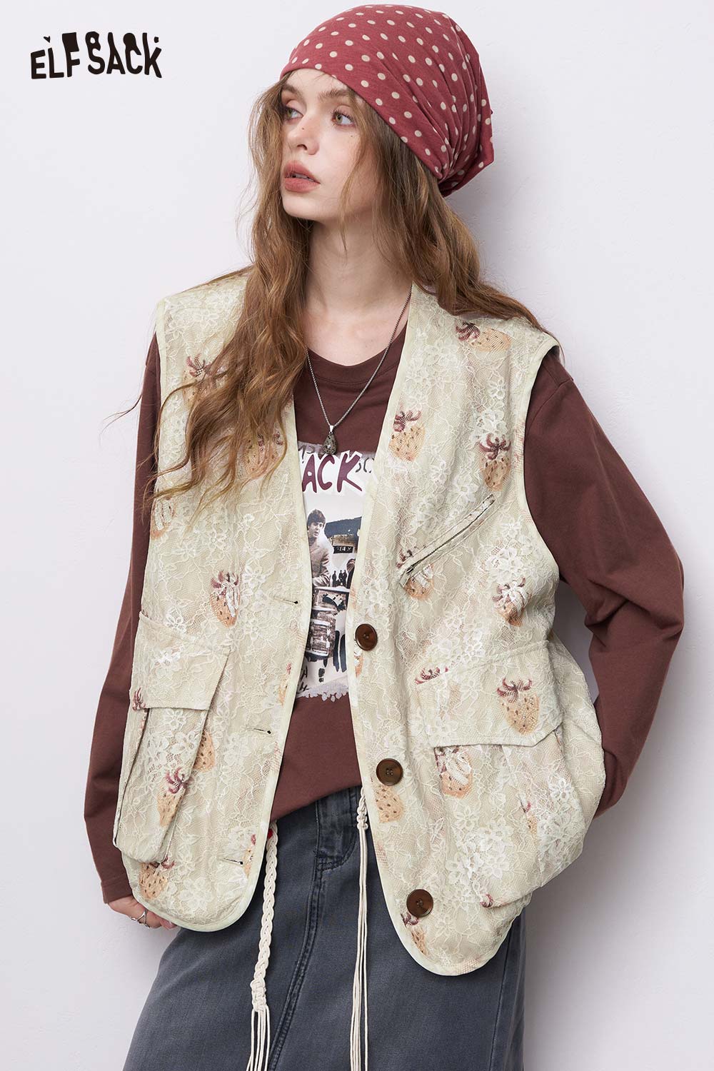 ELFSACK model wearing women's graphic lace vest in cream with embroidered motifs large pockets and wooden buttons