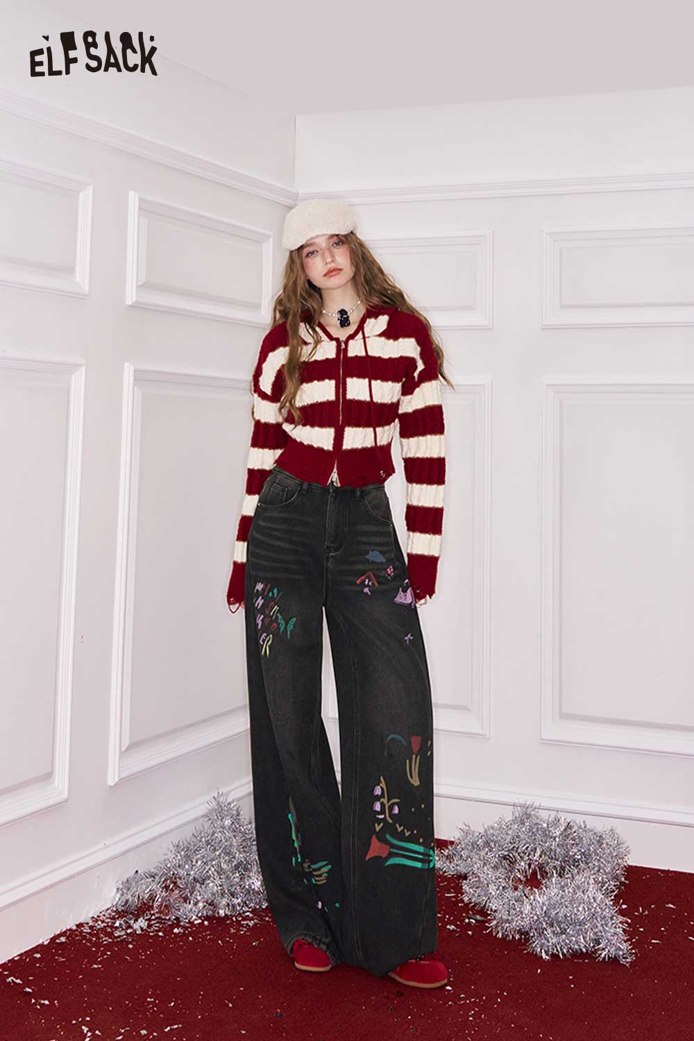 ELFSACK loose straight leg graphic jeans with colorful designs, styled with a cozy striped sweater