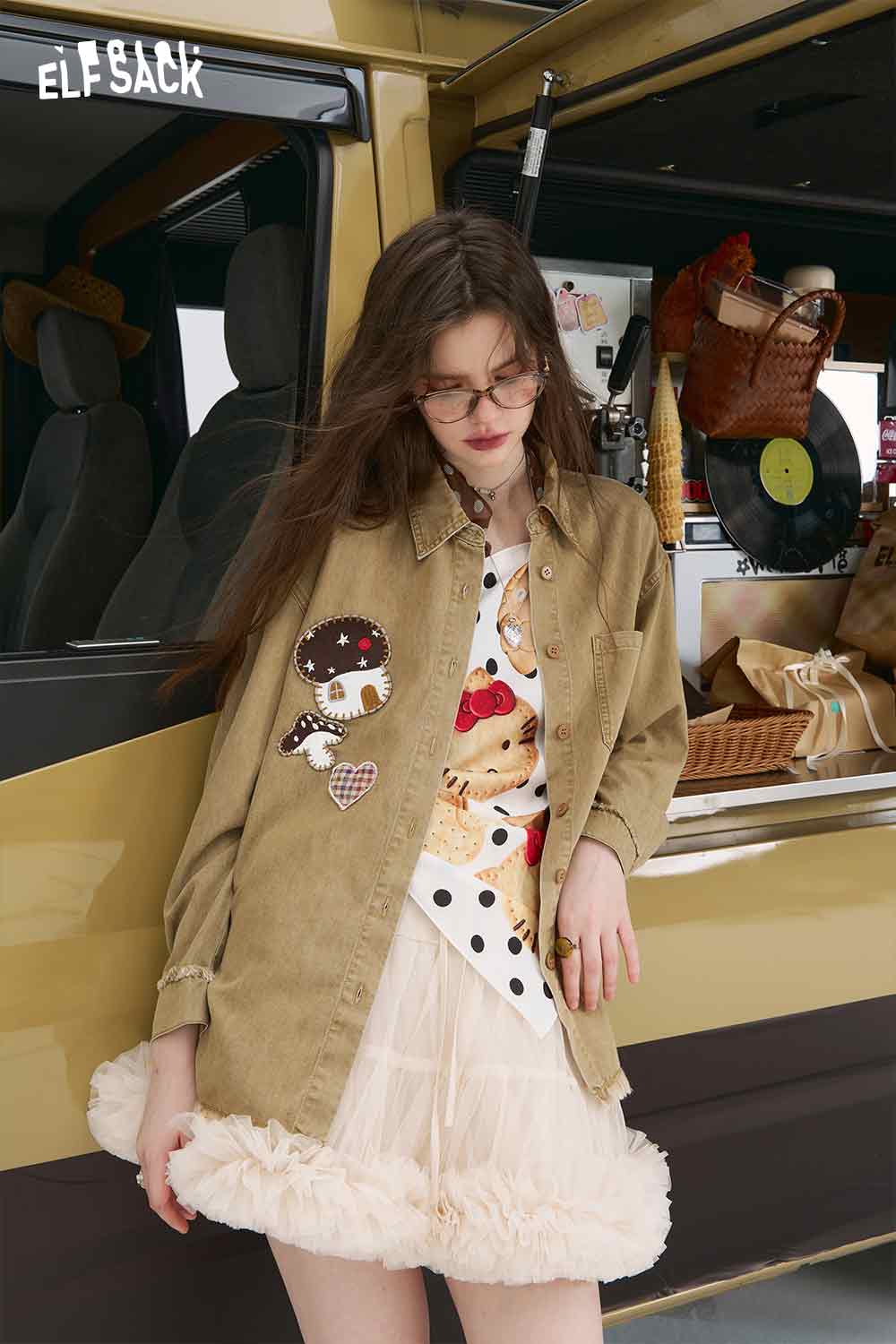 ELFSACK model wearing 3D mushroom denim shirt for women in tan with patch details over ruffled skirt