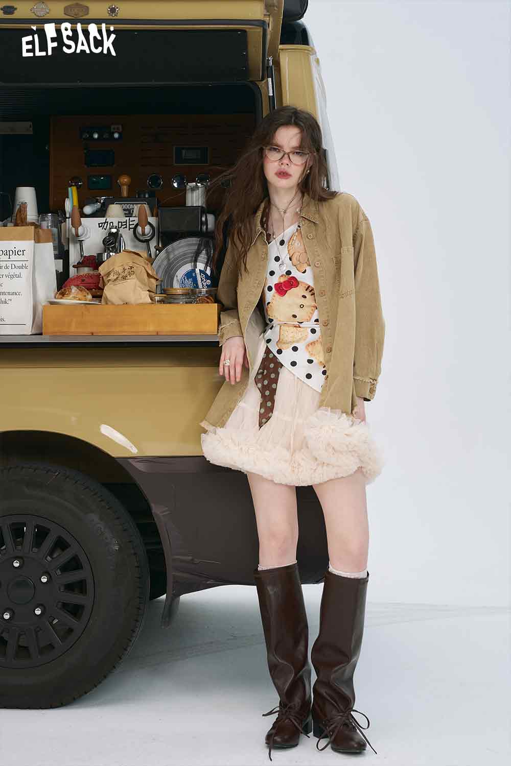 ELFSACK model wearing 3D mushroom denim shirt for women layered under beige jacket with ruffle skirt and brown knee high boots