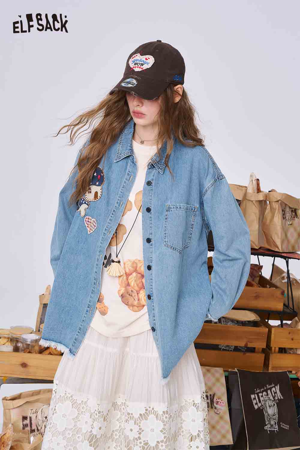 ELFSACK model wearing 3D mushroom denim shirt for women. Oversized light blue denim with mushroom appliques