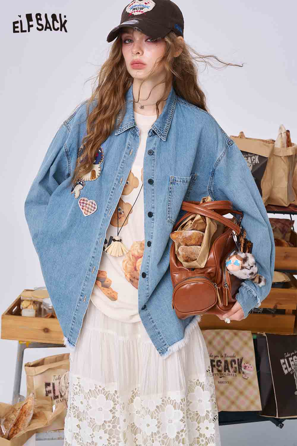 ELFSACK model wearing oversized 3D mushroom denim shirt for women with embroidered patches over white lace skirt