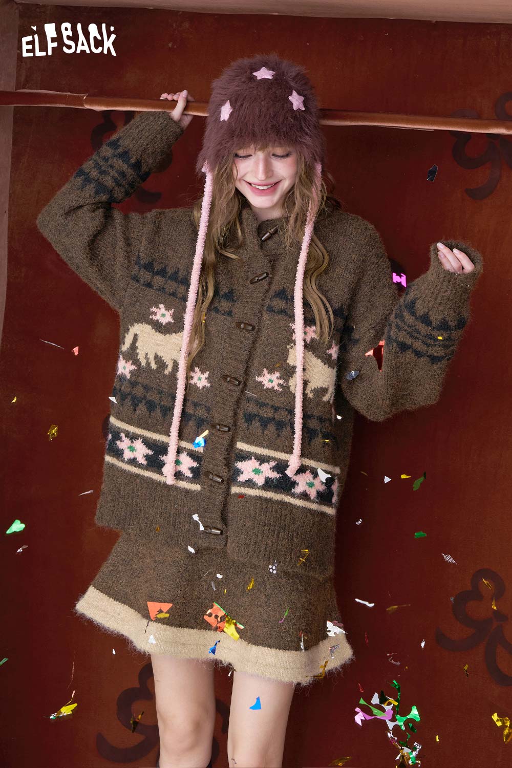 ELFSACK model wearing a cozy outfit with a minimalist Christmas stripe dress paired with a festive hat