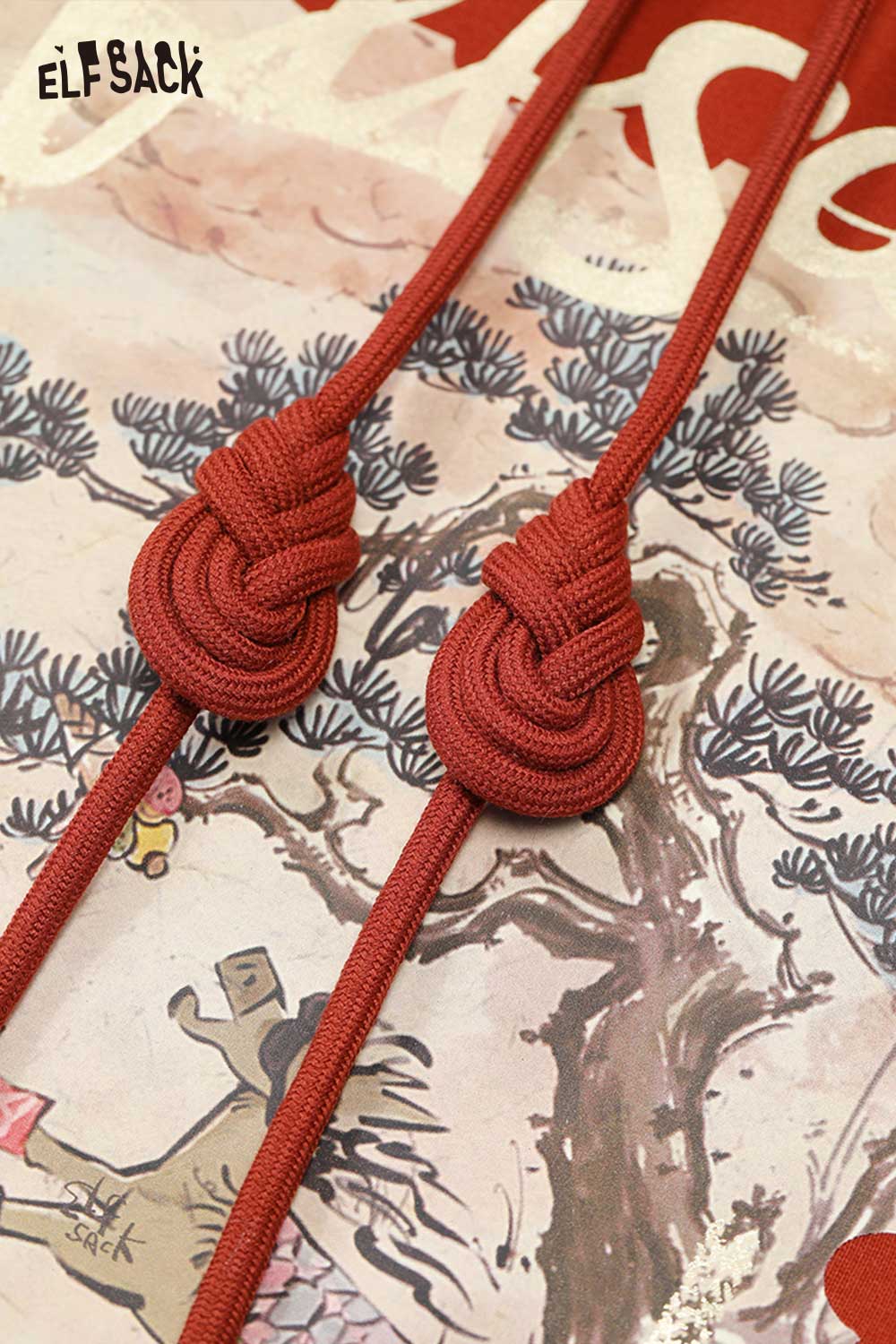 Detail of ELFSACK minimalist graphic hooded sweatshirt with knotted drawstrings on a colorful background