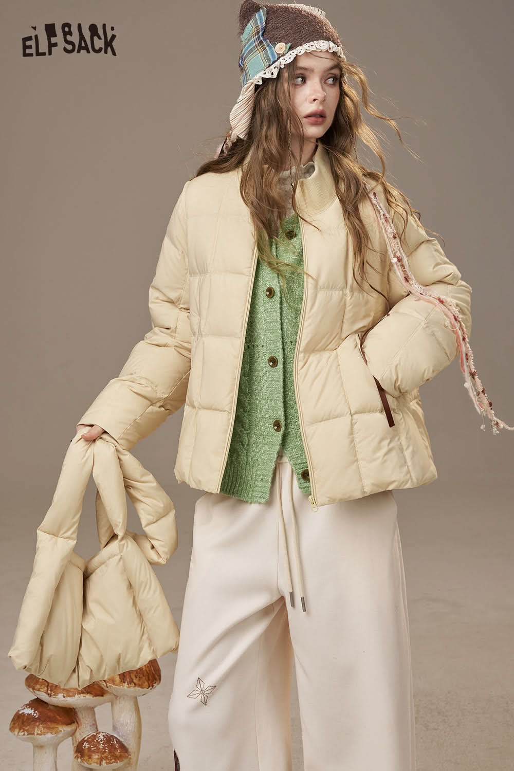 ELFSACK cream puffy jacket styled over a minimalist knit cardigan for women with casual pants