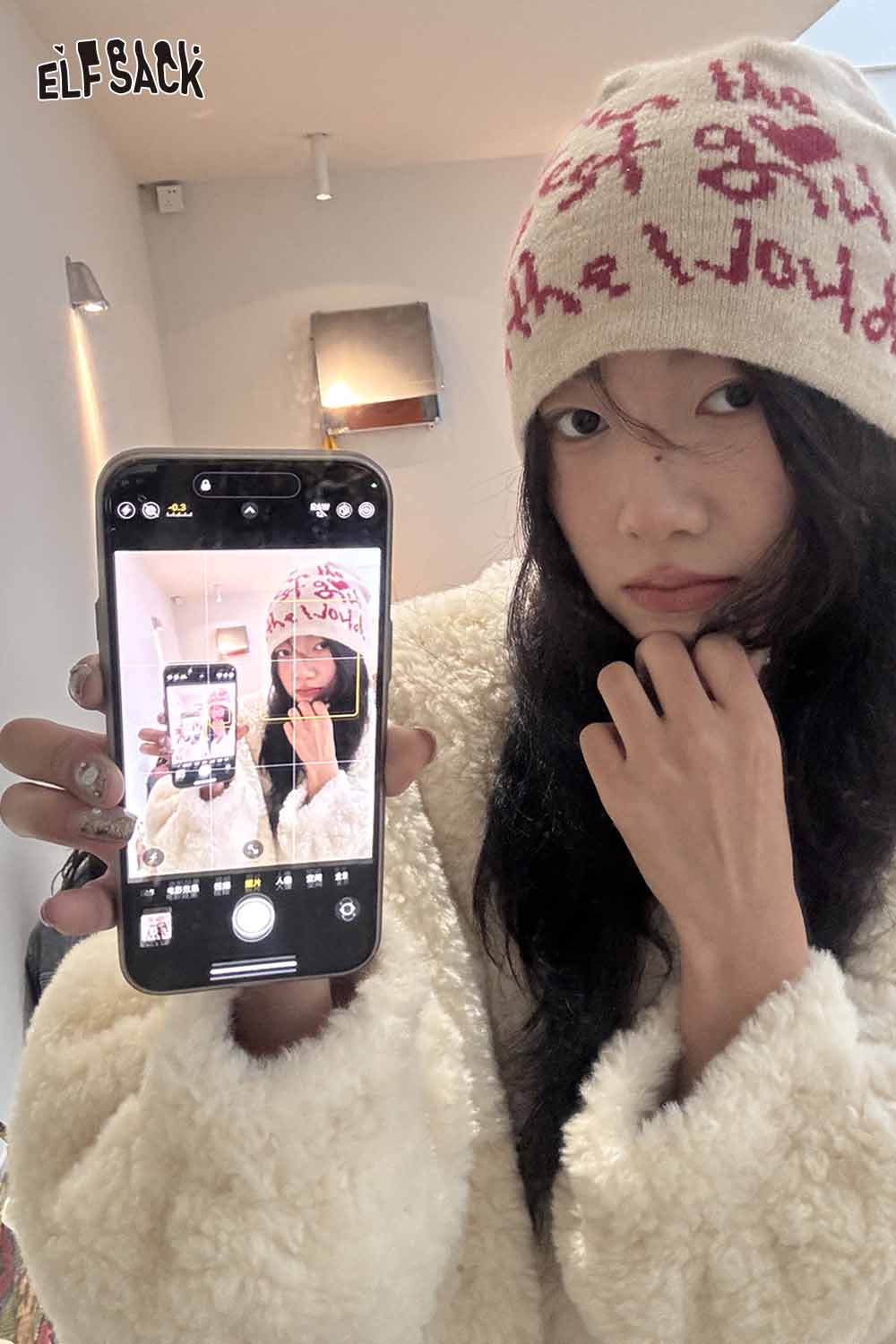 Stylish ELFSACK minimalist letter graphic beanie worn by a model, featuring a cozy design and neutral colors.