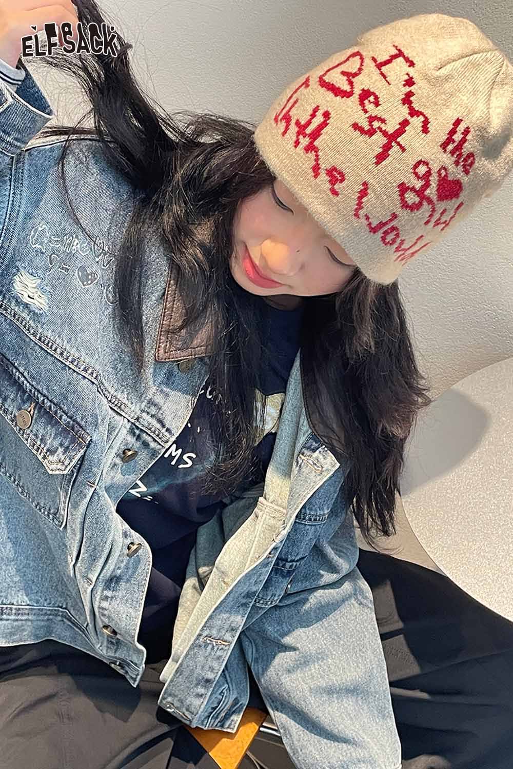 ELFSACK minimalist letter graphic beanie in beige worn by a woman with denim jacket, featuring unique text design