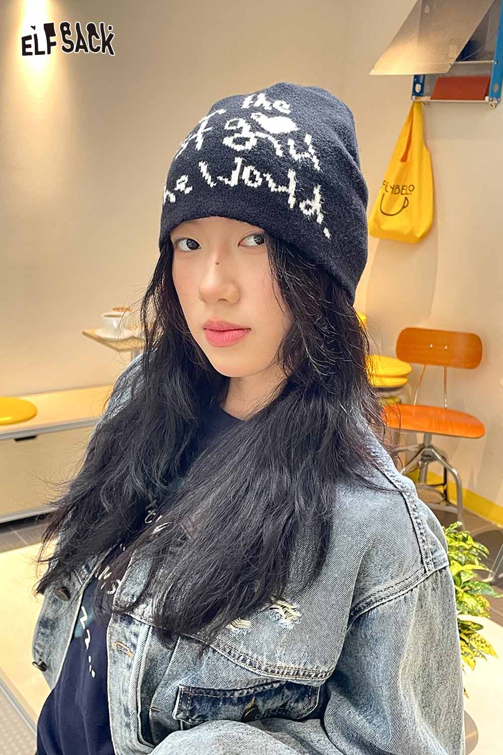 ELFSACK minimalist letter graphic beanie in black worn by a model with long hair and denim jacket