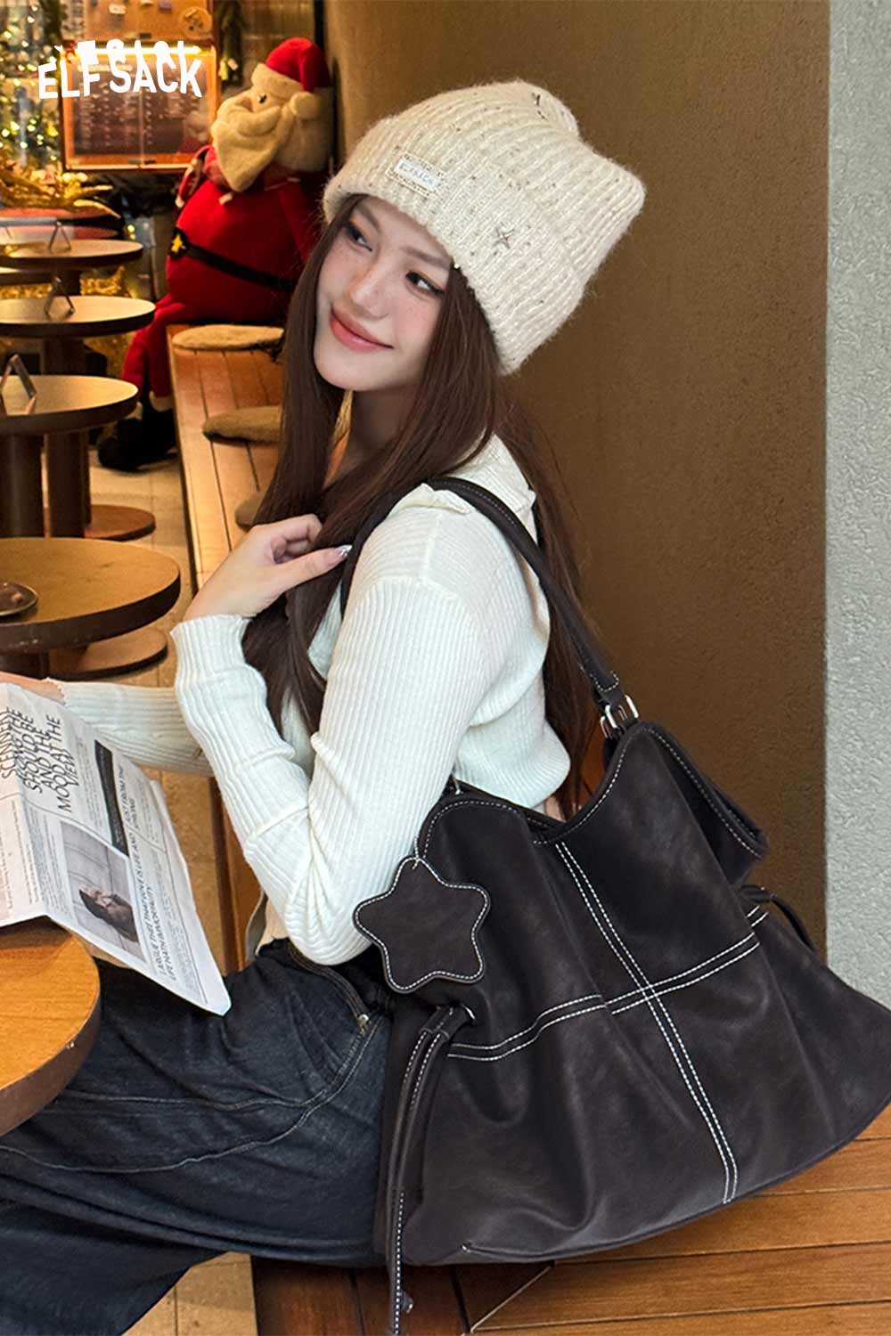 Stylish ELFSACK minimalist PU leather shoulder bag displayed with a model in a cozy café setting