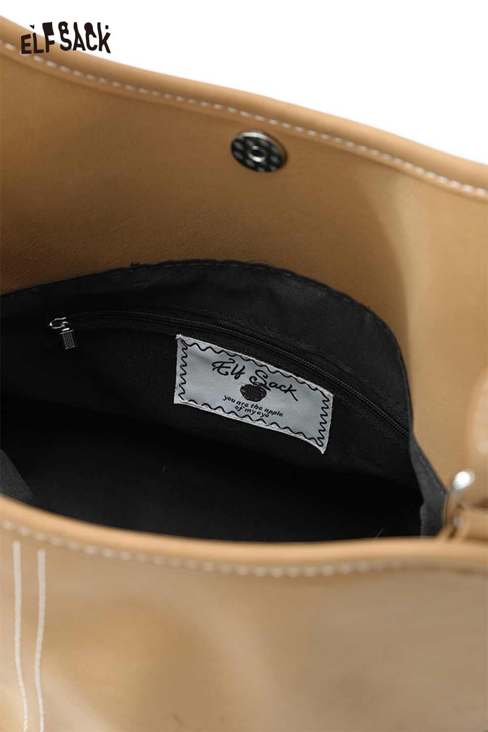 Interior view of minimalist PU leather shoulder bag by ELFSACK featuring a black lining and pocket