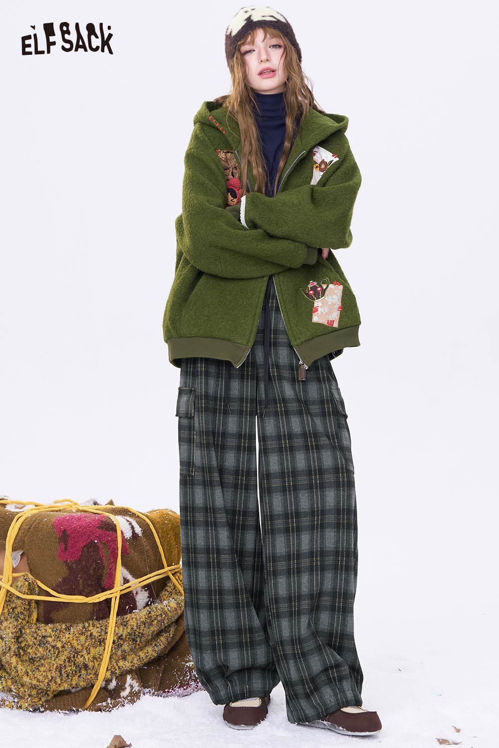 Woman in ELFSACK minimalist stripe wide leg pants paired with a cozy green jacket for a stylish look