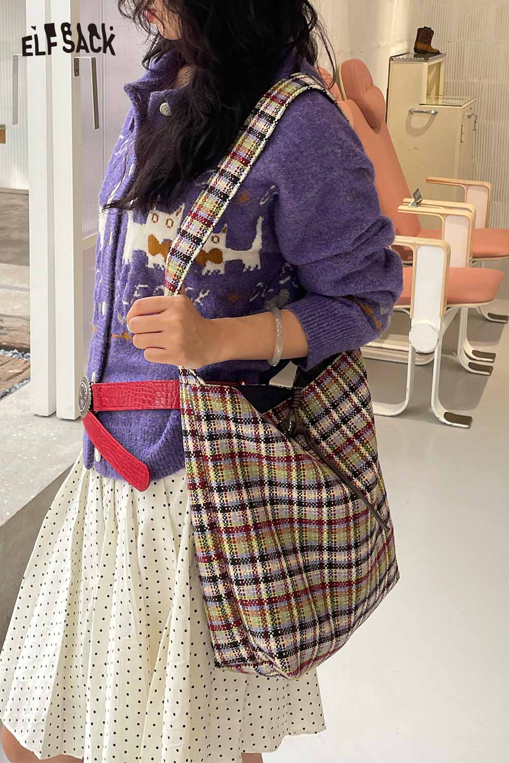 Woman wearing a purple sweater and skirt, holding a multi color checkered shoulder bag for a stylish look