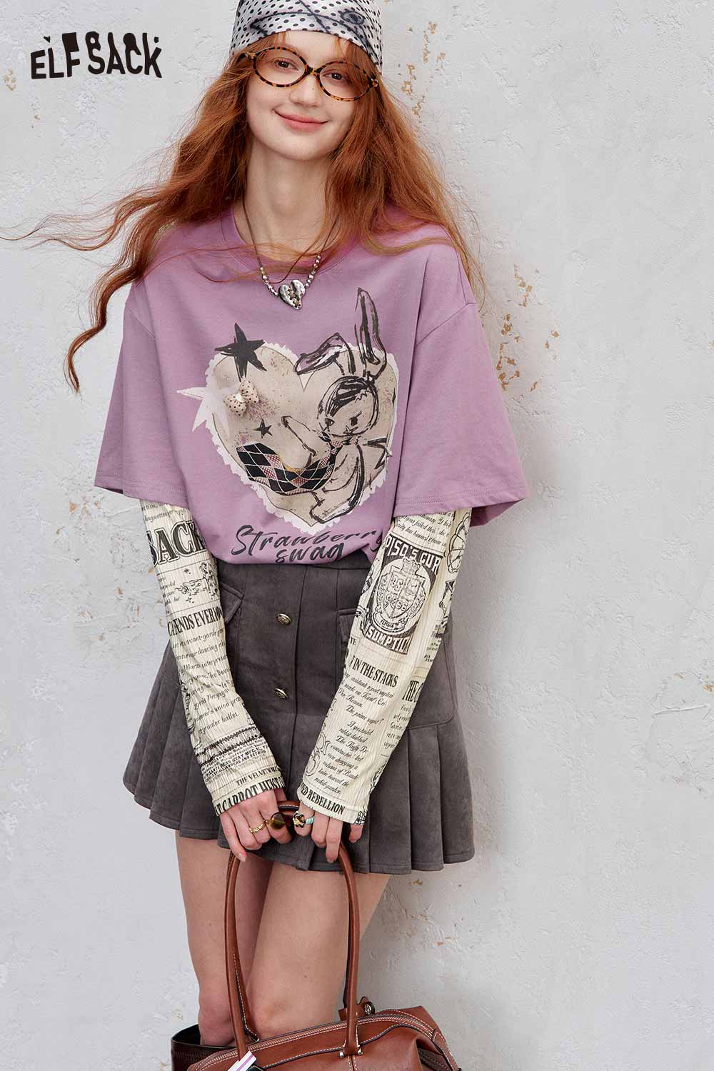 ELFSACK newsprint graphic drop shoulder tee in lavender paired with a pleated grey skirt for a stylish look