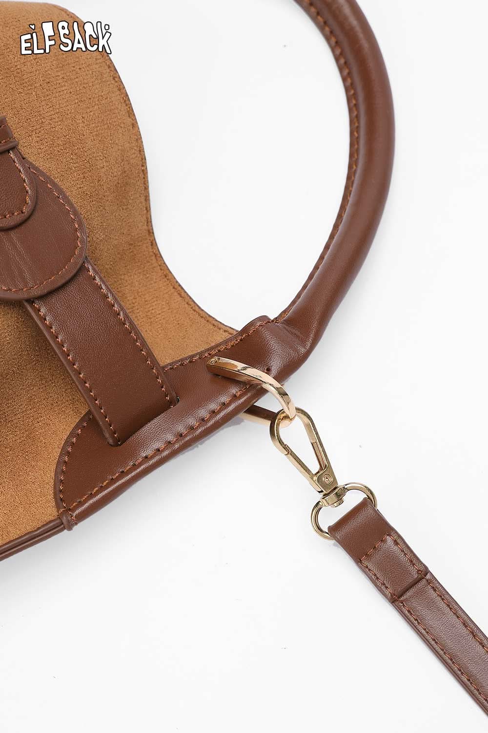 Close-up of ELFSACK nubuck leather crossbody bag with a gold clasp and tan interior