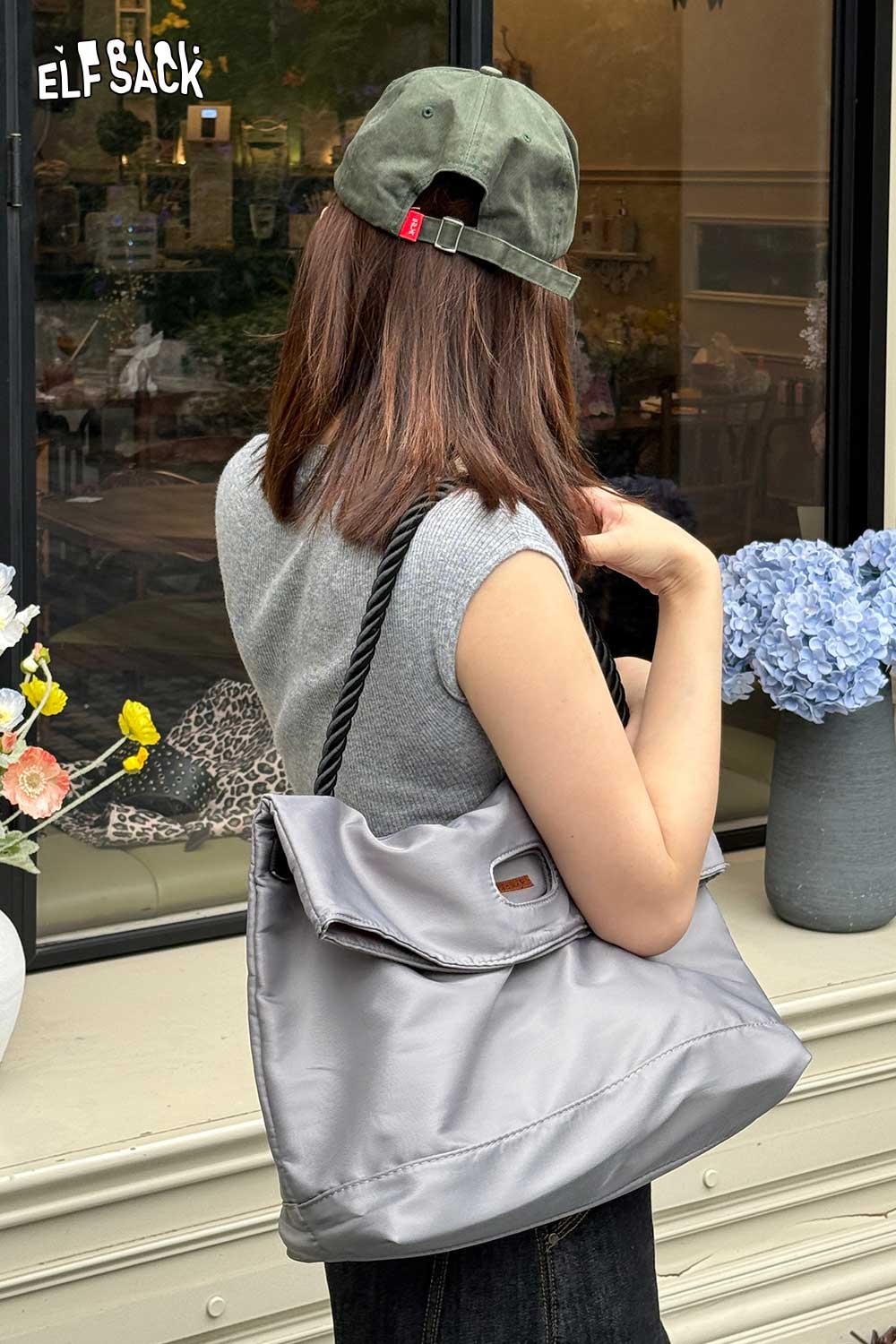 ELFSACK oversized nylon tote bag in grey, stylishly carried by a woman with a cap