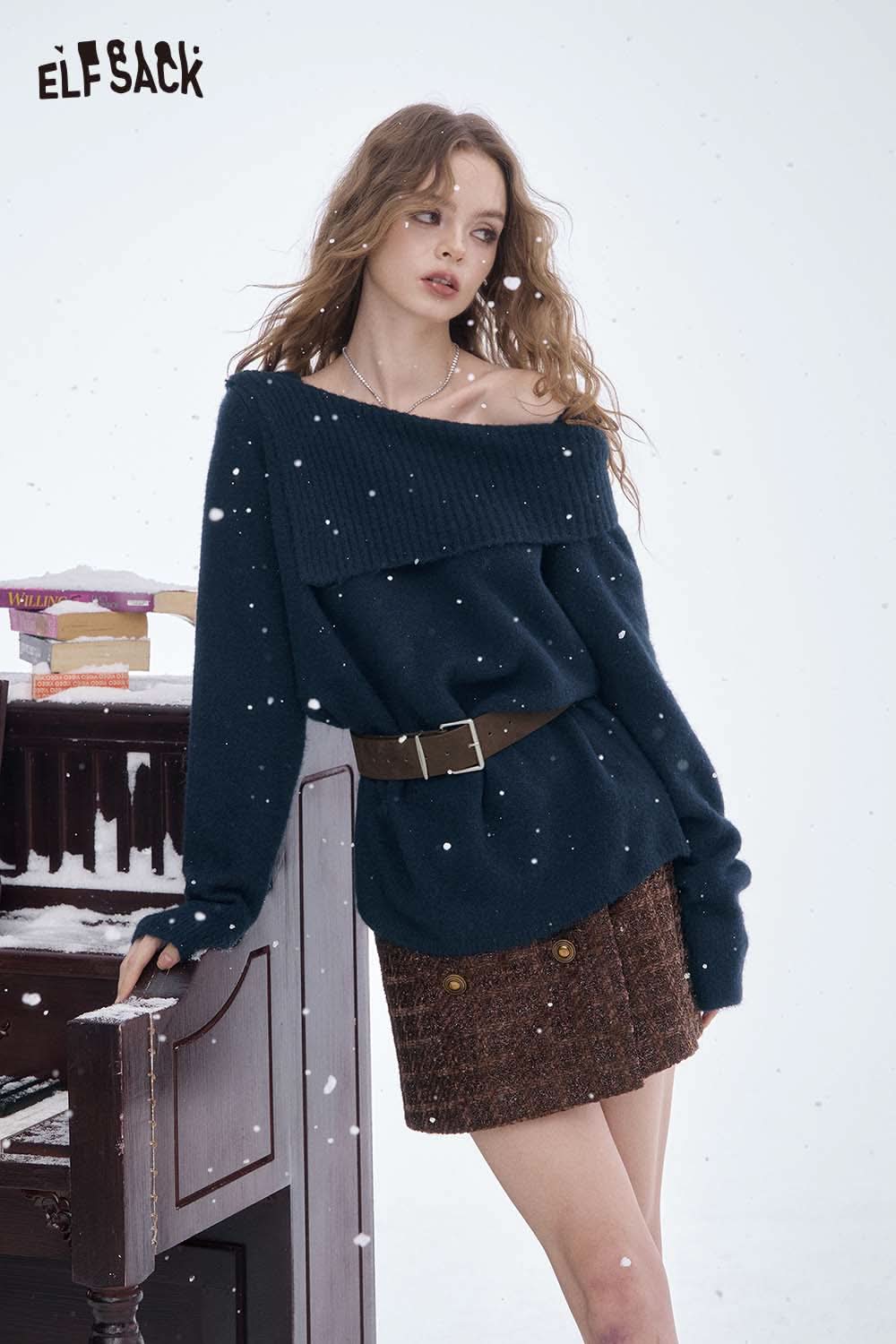 Women's off shoulder knit sweater for women in navy blue styled with a brown skirt in a winter setting