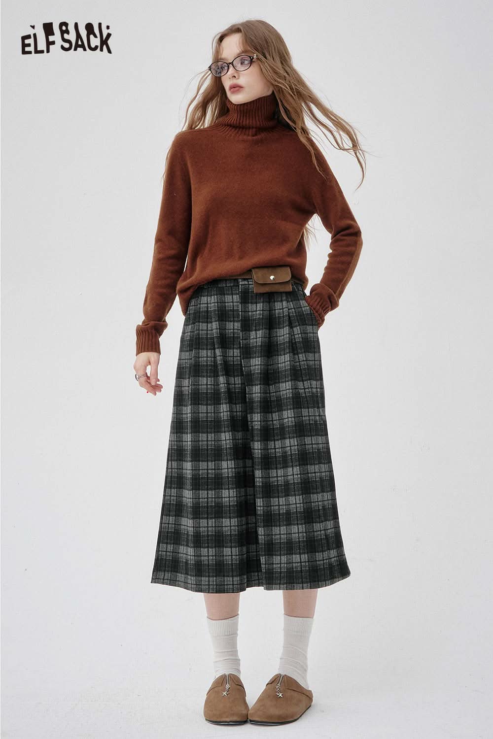 Model wearing off-the-shoulder oversized knit sweater with plaid pants for a stylish look