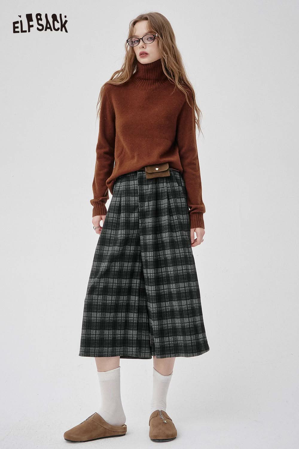 Woman wearing an off-the-shoulder oversized knit sweater with plaid wide-leg pants for a stylish fall look