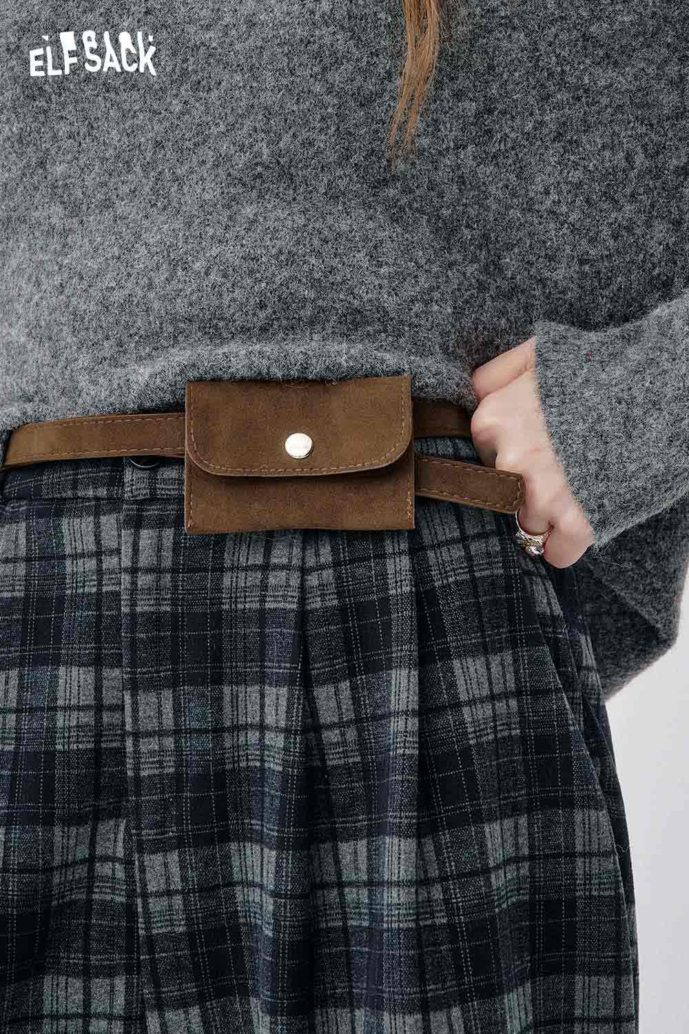 Model wearing off-the-shoulder oversized knit sweater with plaid pants and a brown belt bag