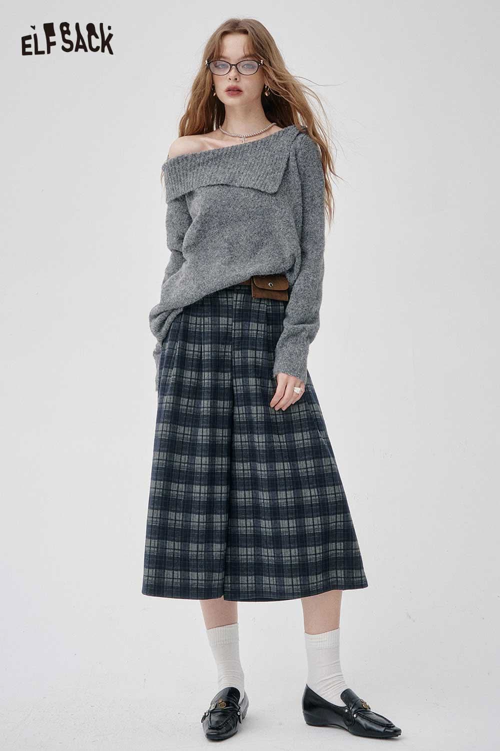 Woman wearing an off-the-shoulder oversized knit sweater paired with plaid pants for a stylish look
