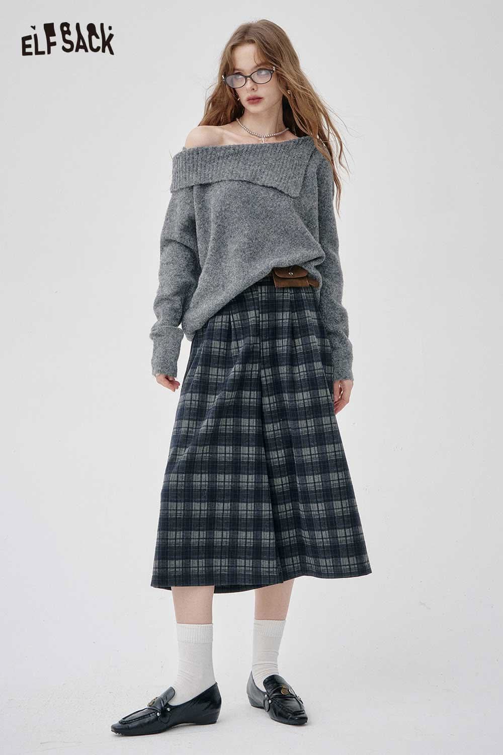Model wearing off-the-shoulder oversized knit sweater paired with plaid skirt for a stylish look