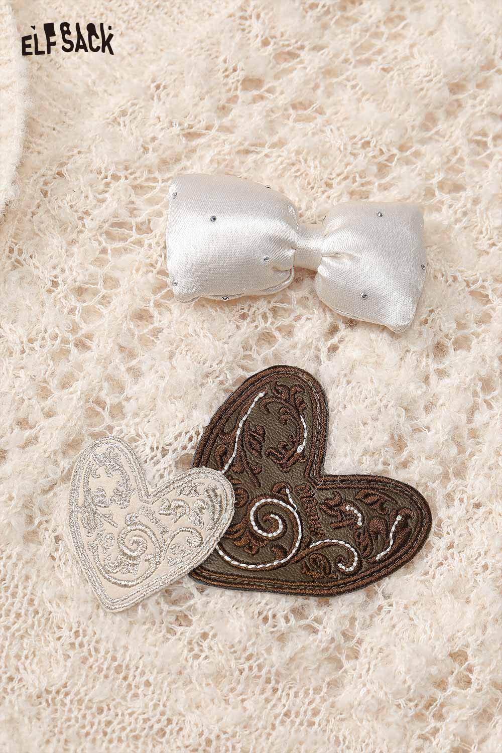 ELFSACK open knit cardigan with bows featuring decorative heart patches and a stylish design