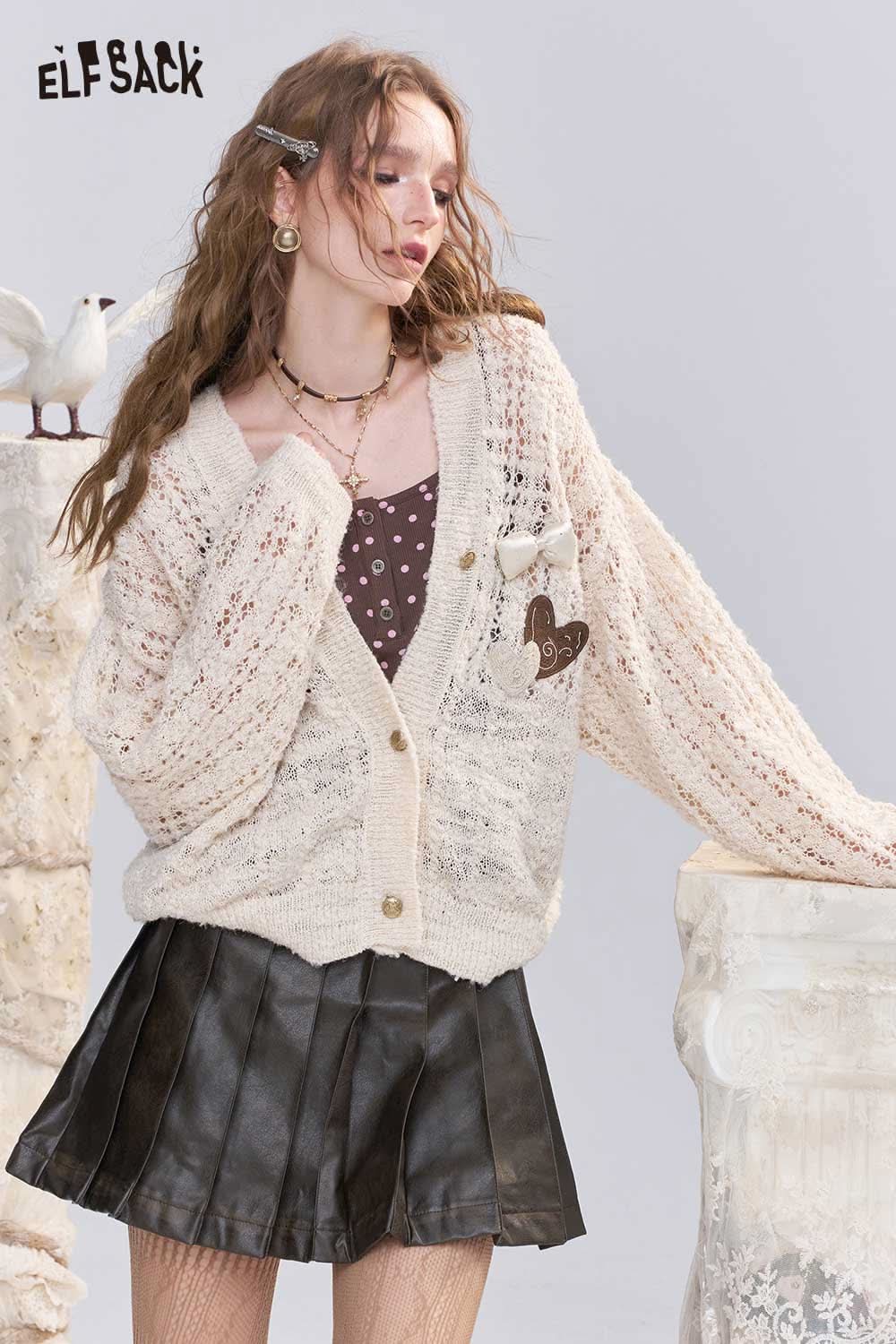 ELFSACK open knit cardigan with bows in cream color, styled with a polka dot top and a skirt