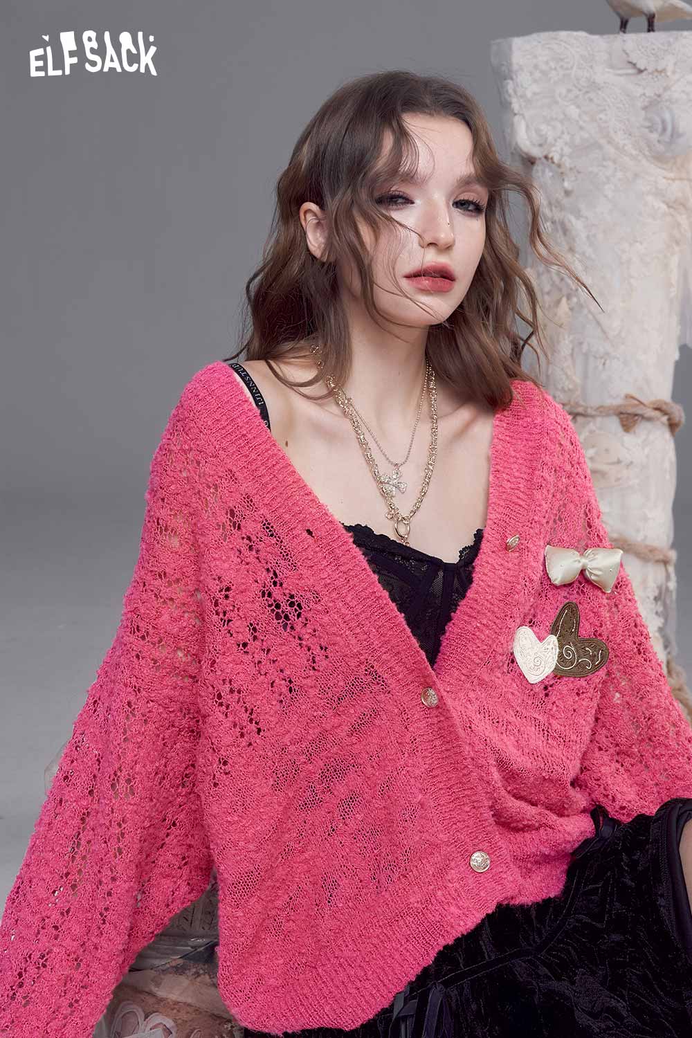 ELFSACK open knit cardigan with bows in vibrant pink, styled with layered necklaces for a chic look