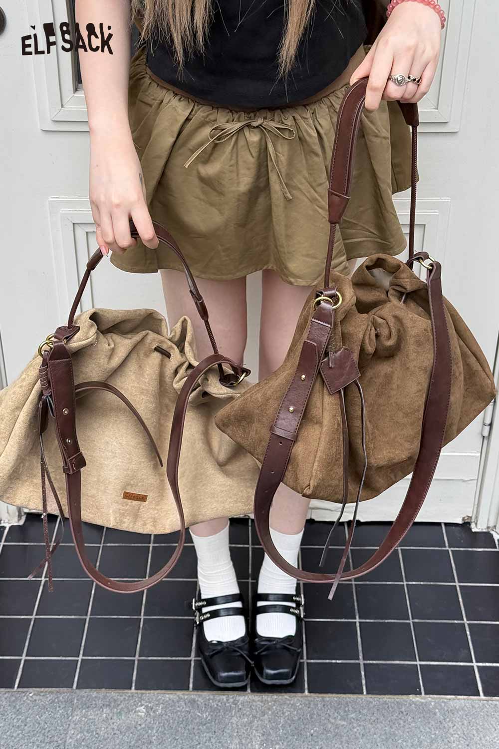 Two ELFSACK oversized tote bags for women in different colors, held by a person wearing a skirt and black shoes