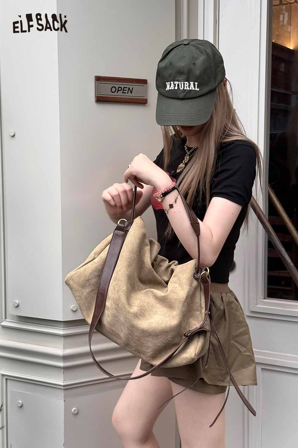 Stylish oversized tote bag for women held by a model in casual attire outside a shop