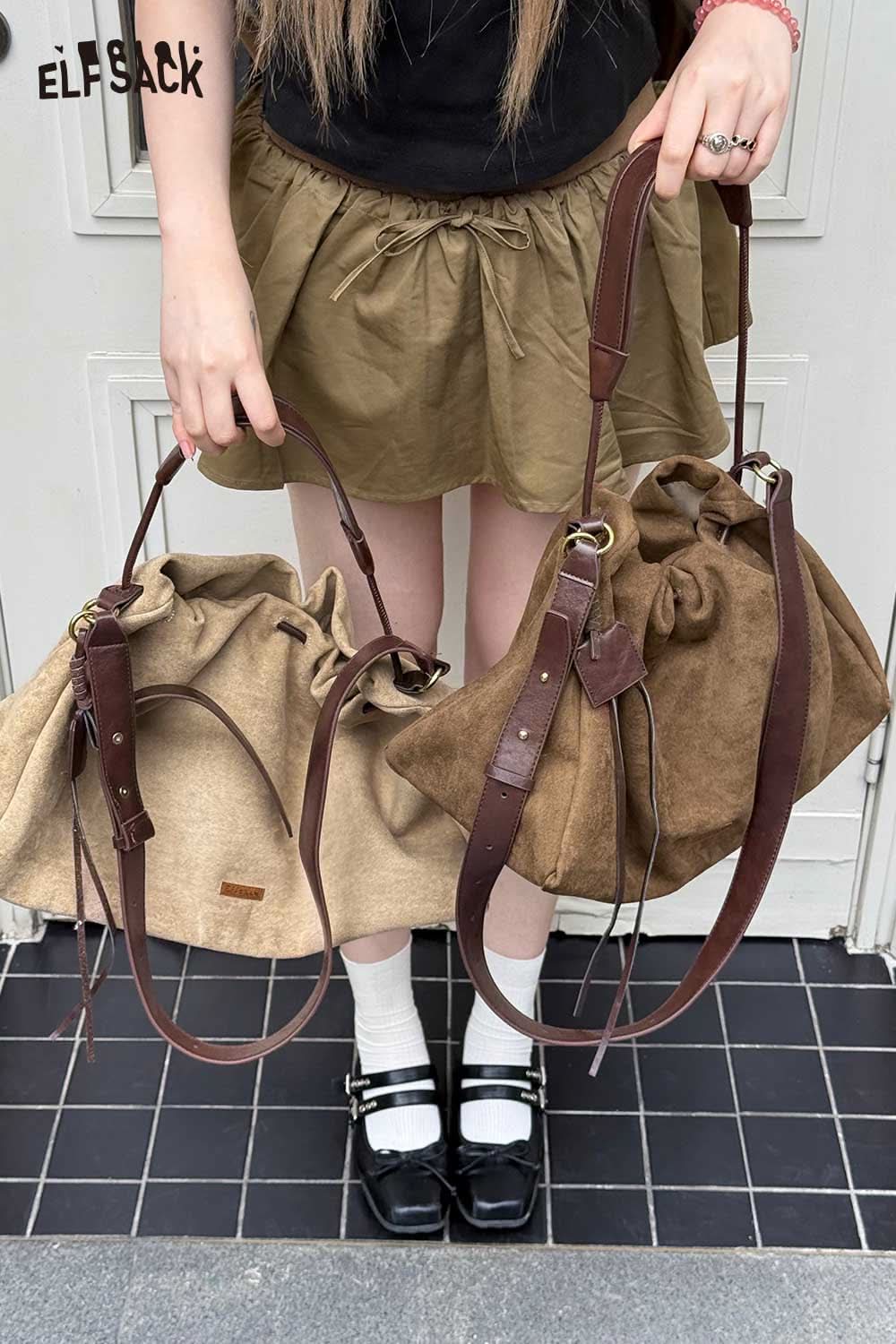 Two ELFSACK oversized tote bags for women, one in beige and one in brown, held by a person in a skirt and shoes