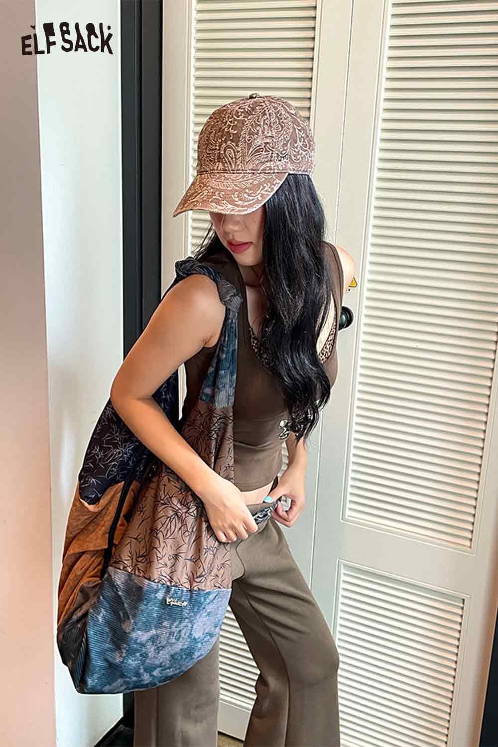 Stylish ELFSACK paisley print bucket hat for women paired with a casual outfit and a unique bag