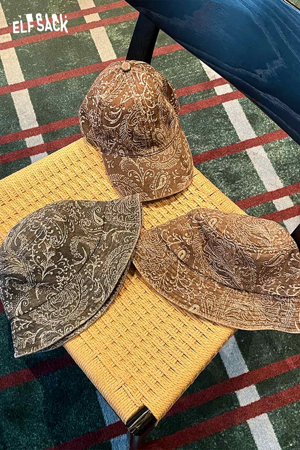ELFSACK paisley print bucket hat for women in brown tones displayed on a woven surface