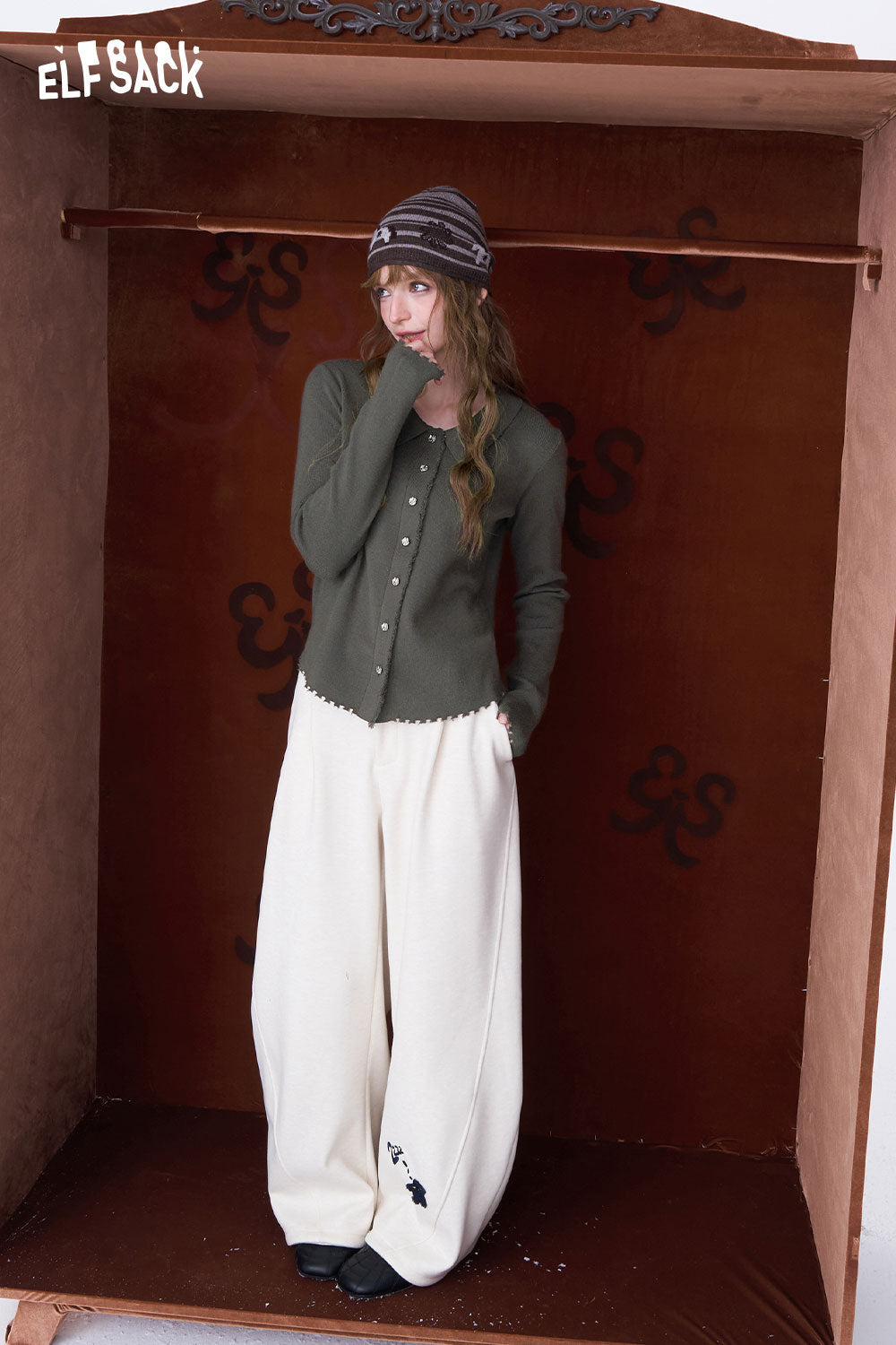 Fashion model wearing a green peter pan collar knit sweater paired with cream wide-leg pants