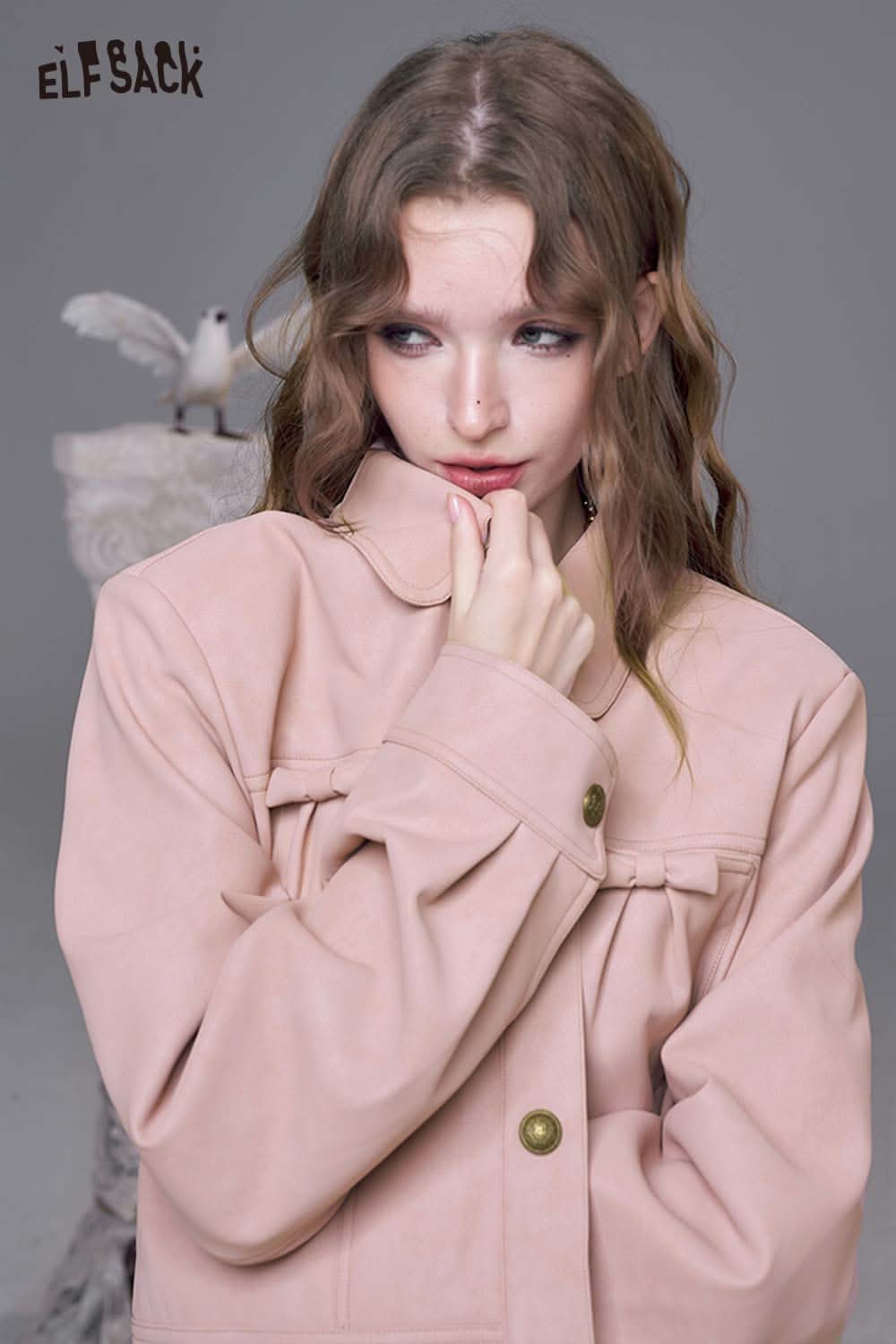 Model wearing a stylish pink faux leather motocross jacket with a relaxed fit and large buttons
